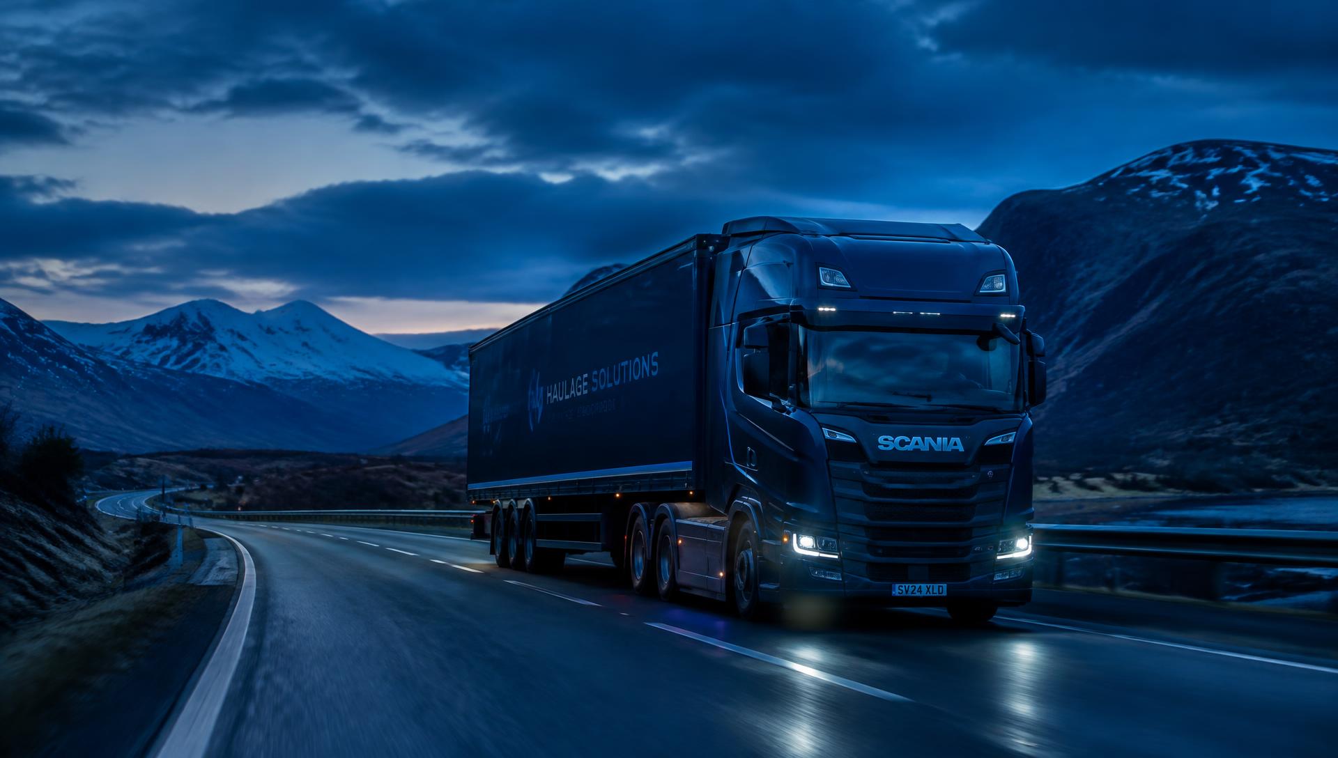 HGV lorry driving through the Scottish Highlands at dusk